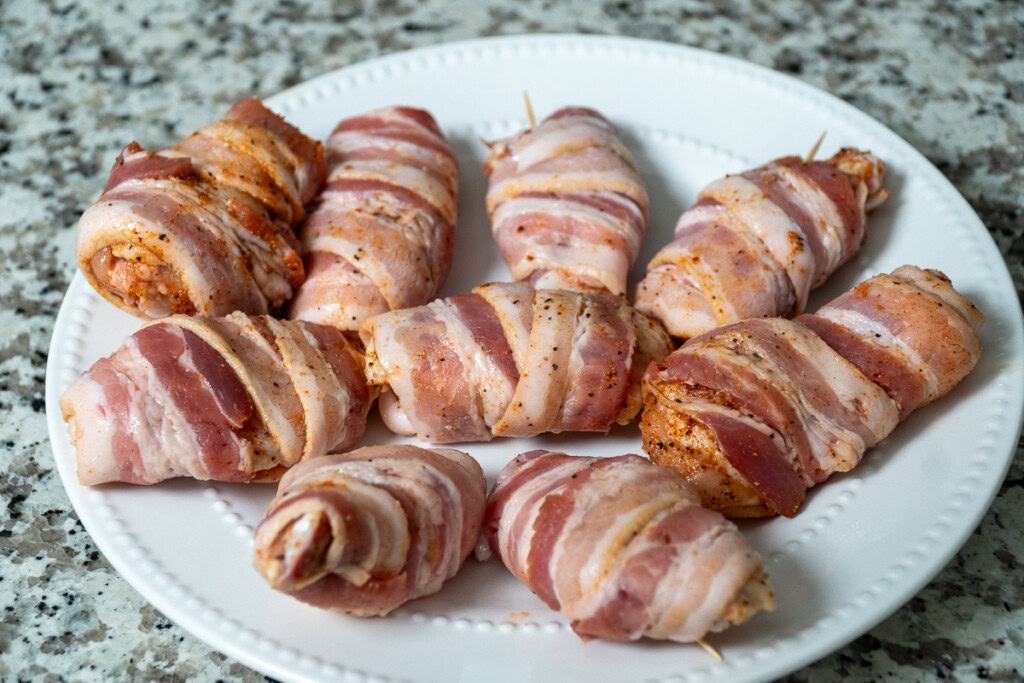 a plate of raw, bacon wrapped wings