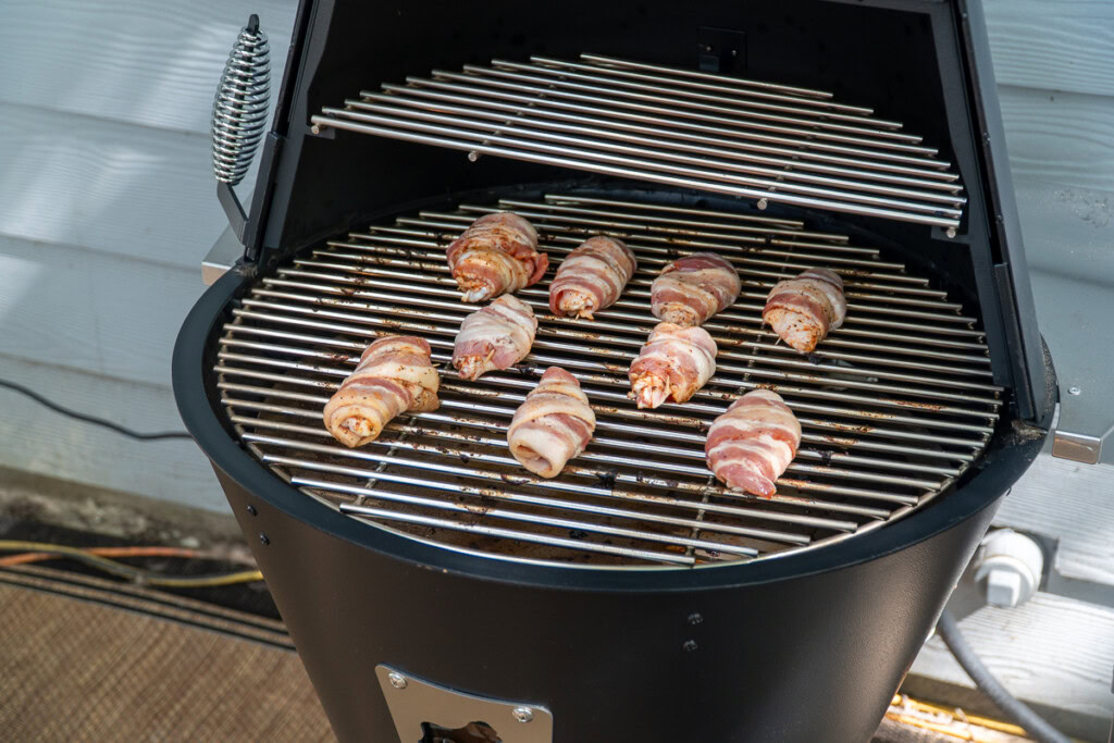 raw bacon wrapped chicken wings on the grilla grills smoker