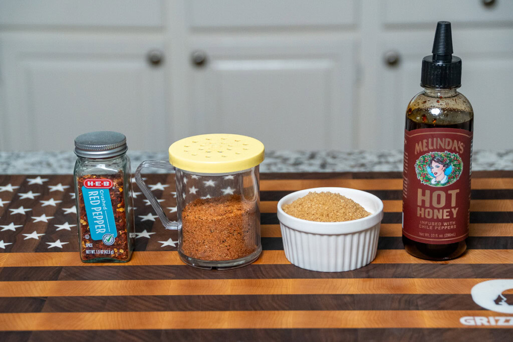ingredients for billonaire bacon crackers laid out on a wooden board