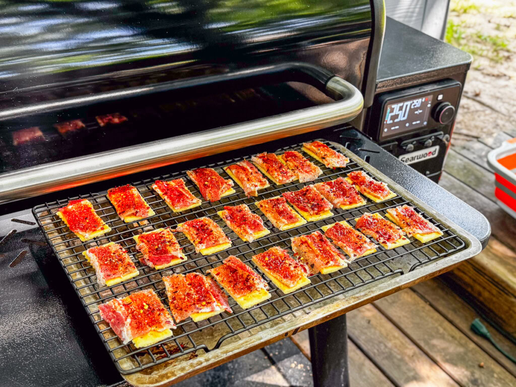 uncooked bacon topped crackers ready to go into the smoker