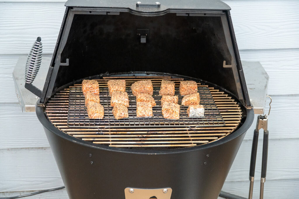 a wire rack of raw seasoned salmon cubes in the grilla grill