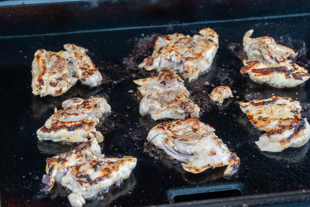 chicken thighs cooking on the griddle