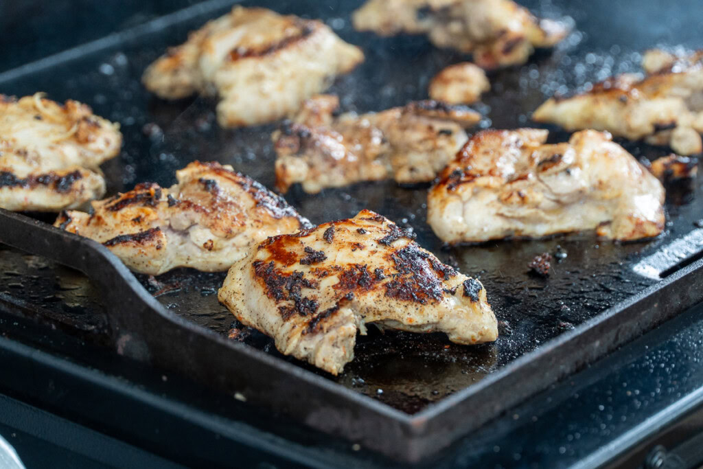 nicely charred chicken thighs on the griddle