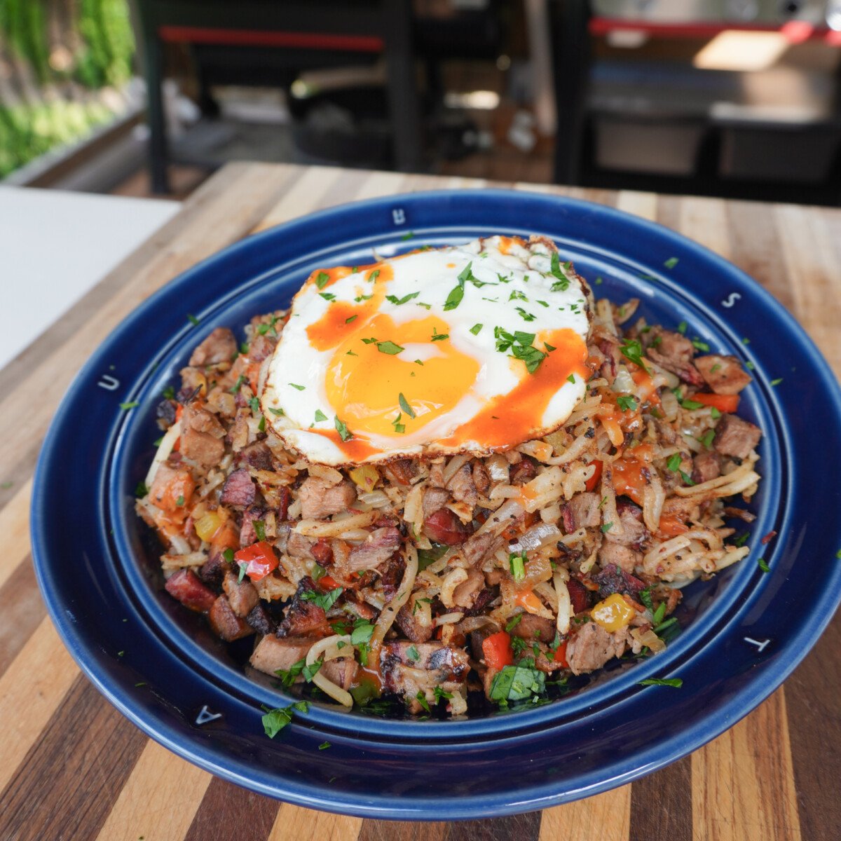 Easy Brisket hash plated with an over easy egg on top.