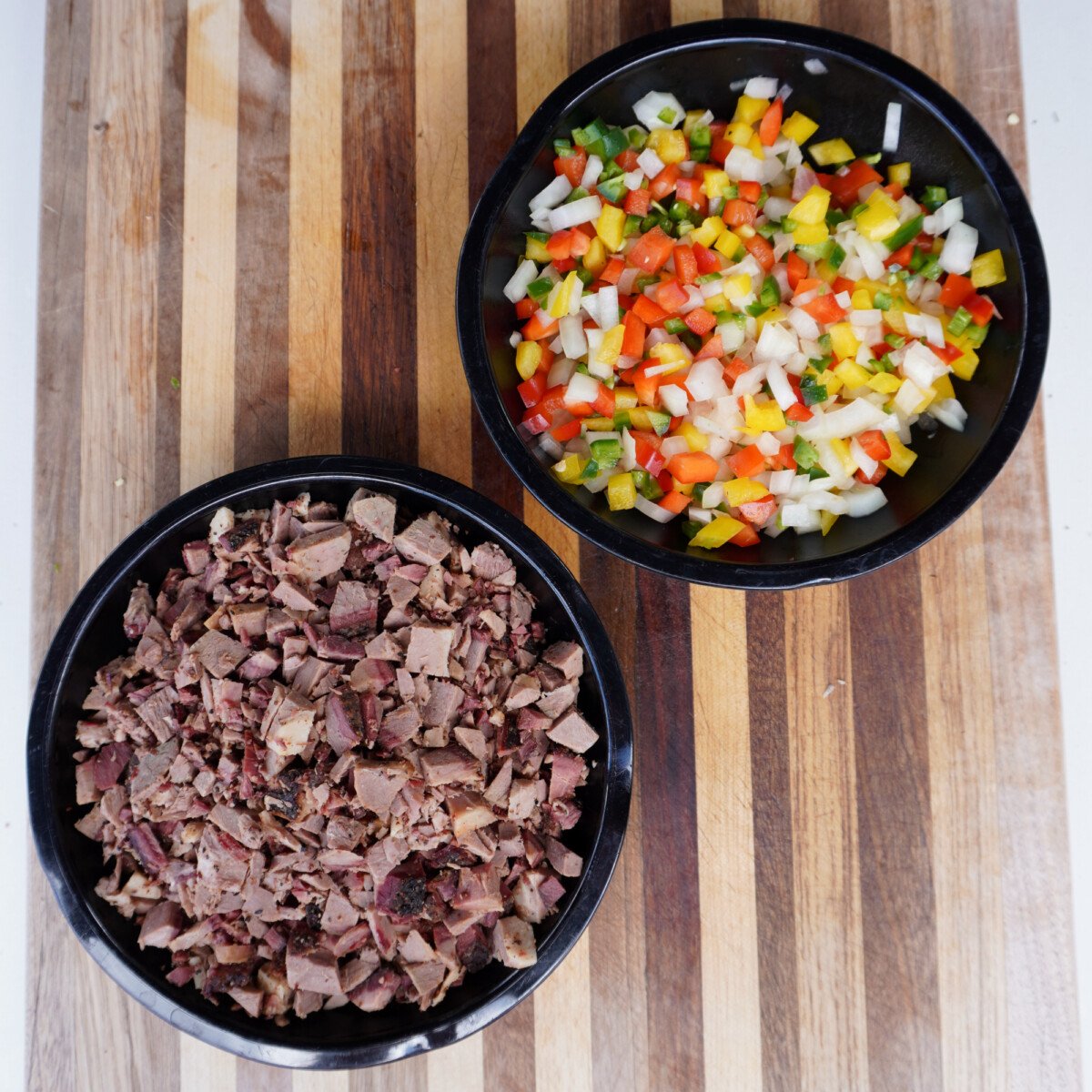 prepared chopped ingredients in black bowls.