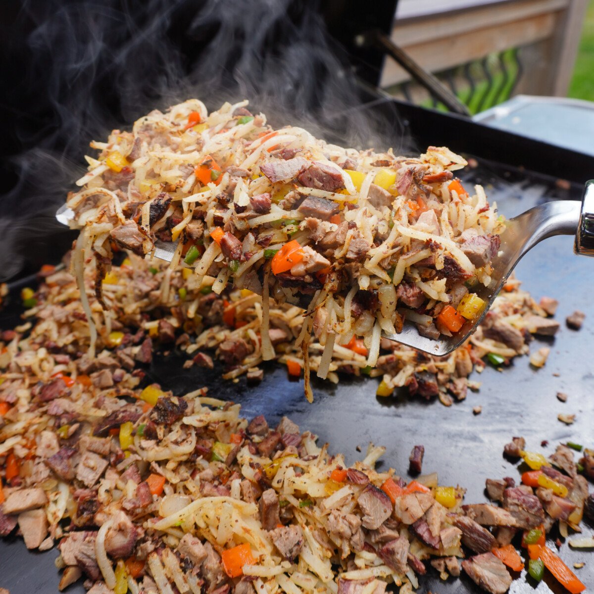 Cooked brisket hash scooped up on a spatula.