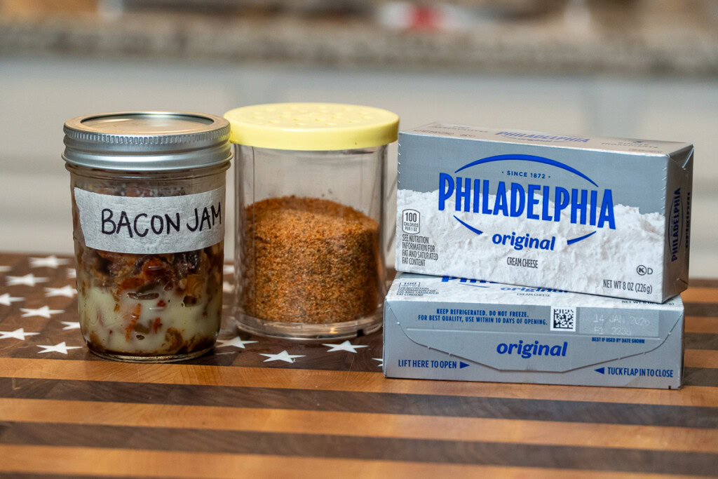 ingredients for smoked cream cheese and bacon jam laid out on a wooden chopping board