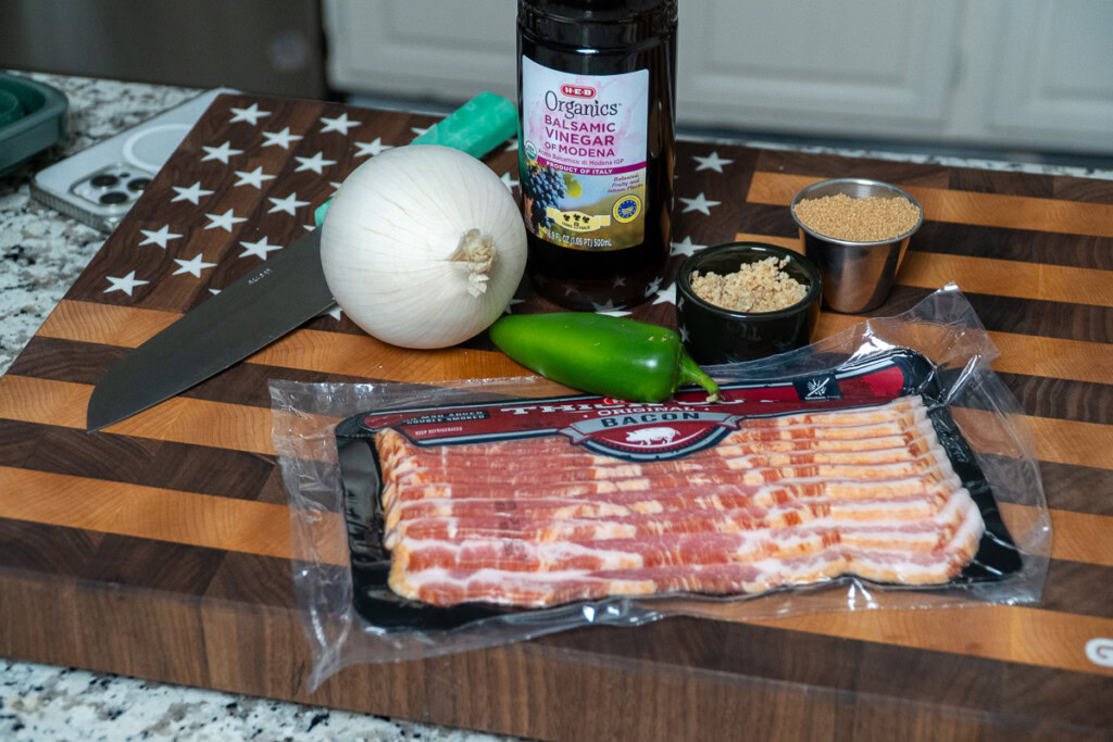 ingredients for bacon jam laid out on a wooden board