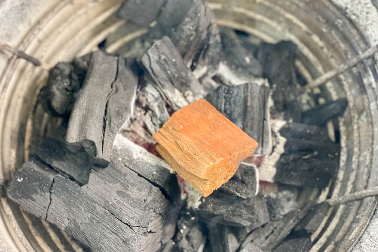 wood chunk sitting on charcoal in big green egg