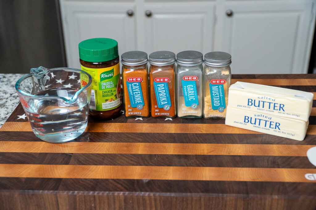 the ingredients for smoked chicken injection lined up on a wooden board