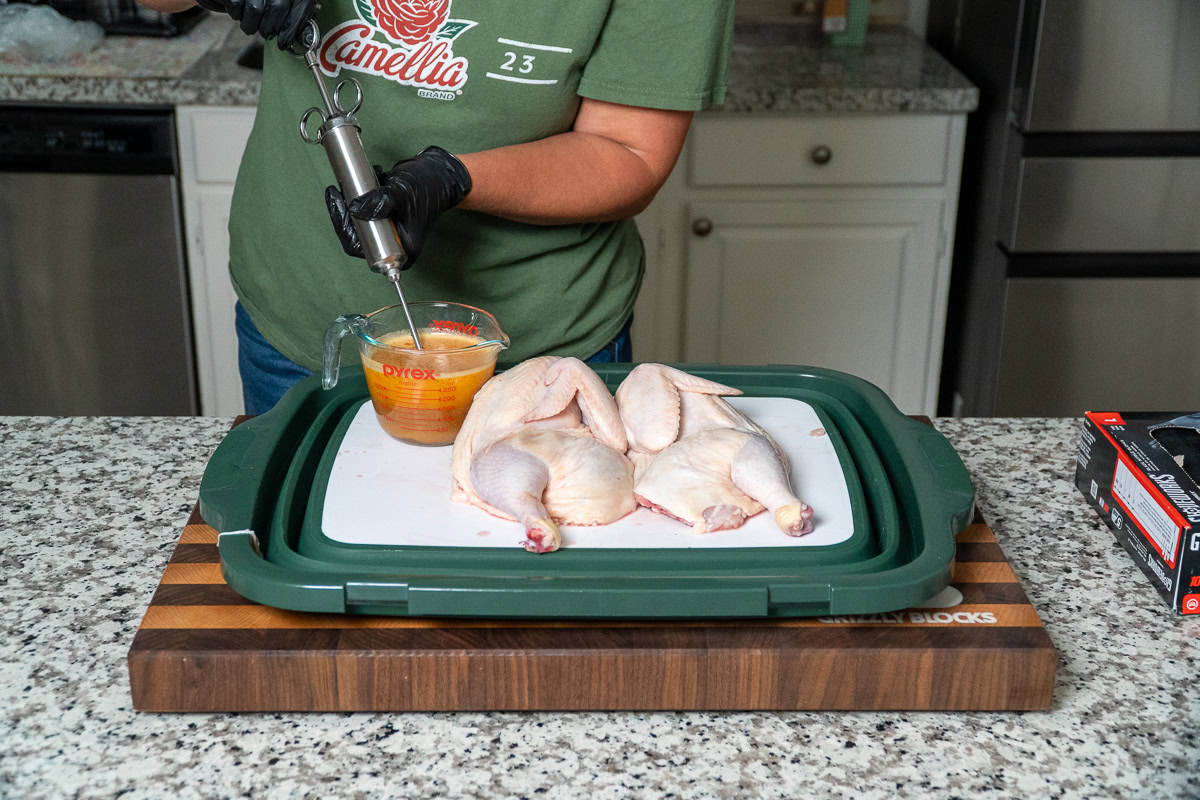 a person filling an injector for the chicken