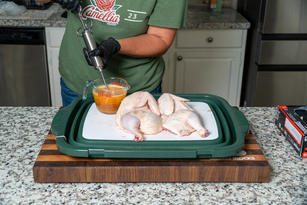 a person filling an injector for the chicken