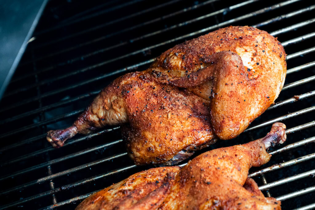 cooked chicken halves on the smoker