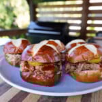 Smoked Pulled Pork with Mustard BBQ Sauce sandwiches on pretzel buns.