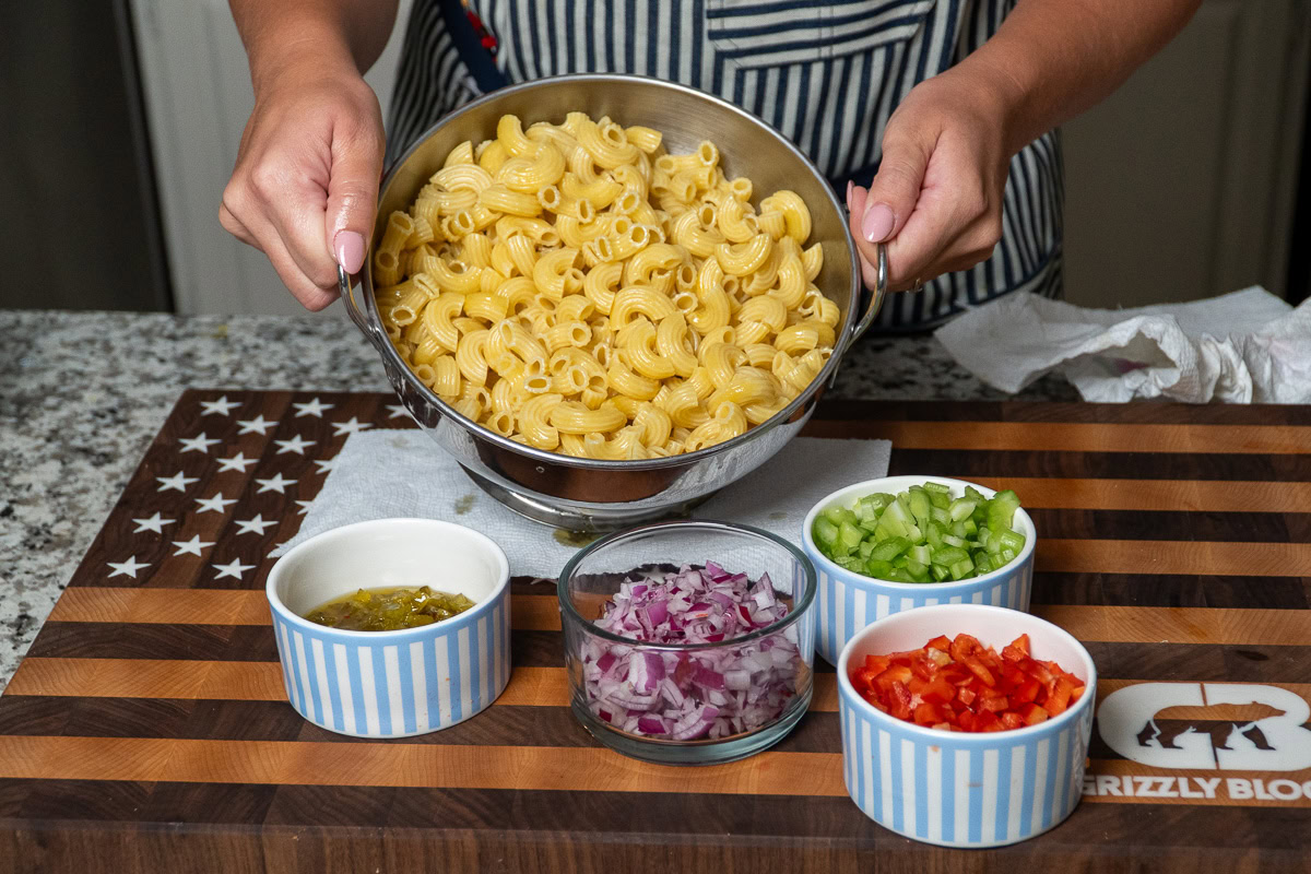 all the ingredients for macaroni salad in individual bowls ready to be put together
