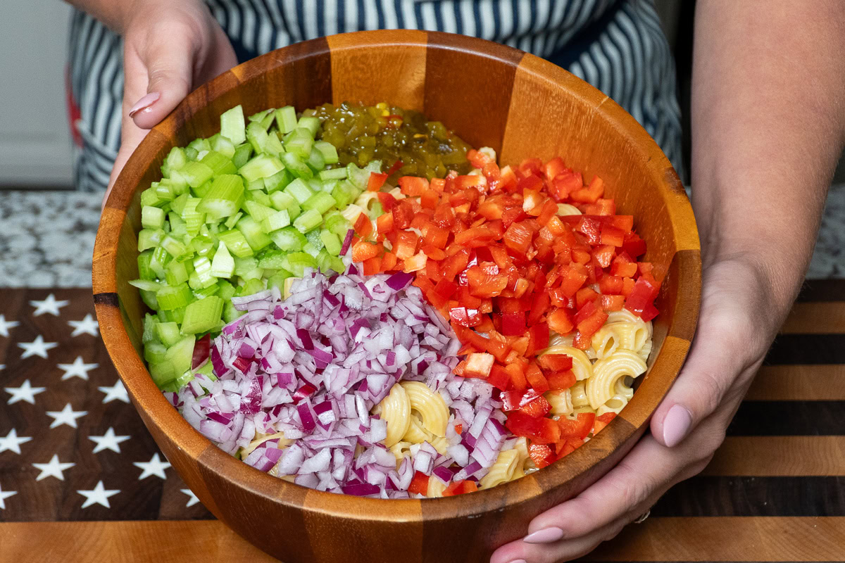 all the ingredients for the macaroni salad in a wooden bowl, minus the dressing