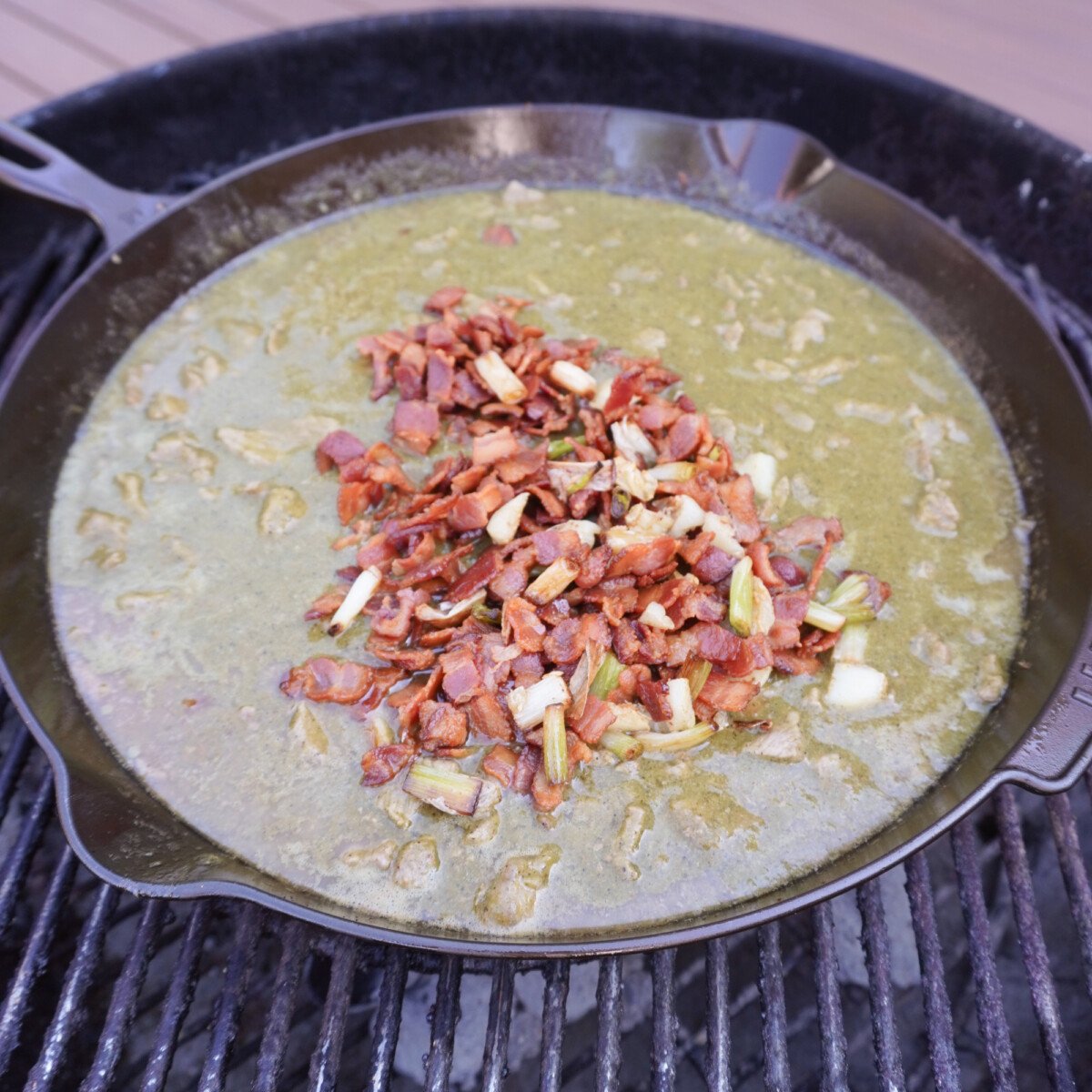 Grilled carne en su jugo in a cast iron skillet over a charcoal grill.