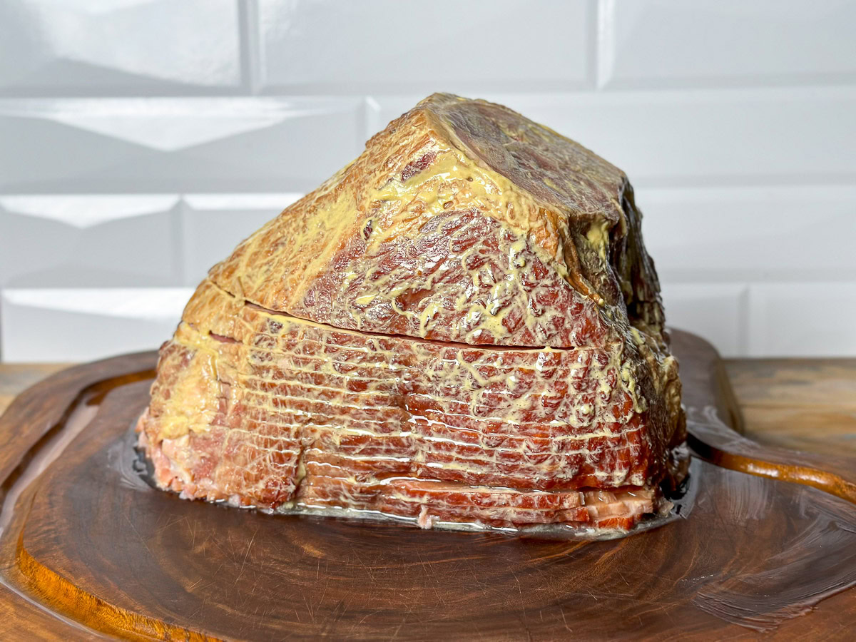 a smoked spiral ham covered in a mustard binder