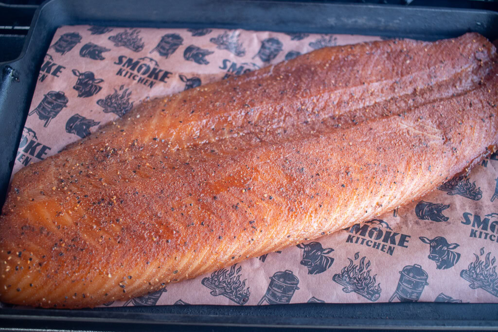 a piece of seasoned salmon on butcher paper in the smoker