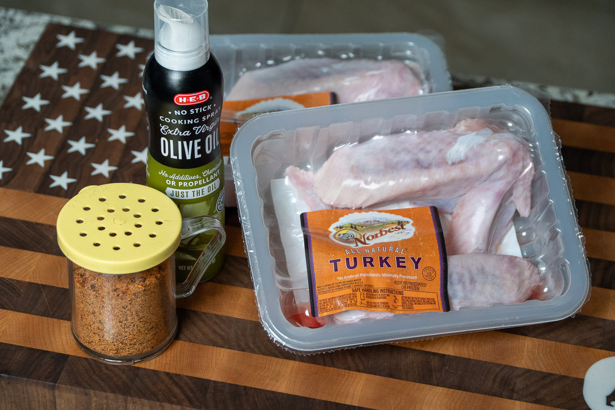 the ingredients for smoked turkey wings laid out on a wooden board