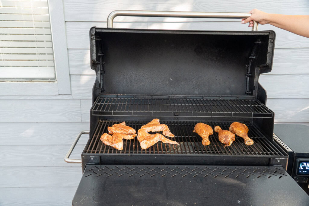 raw seasoned turkey wings and drums on the smoker