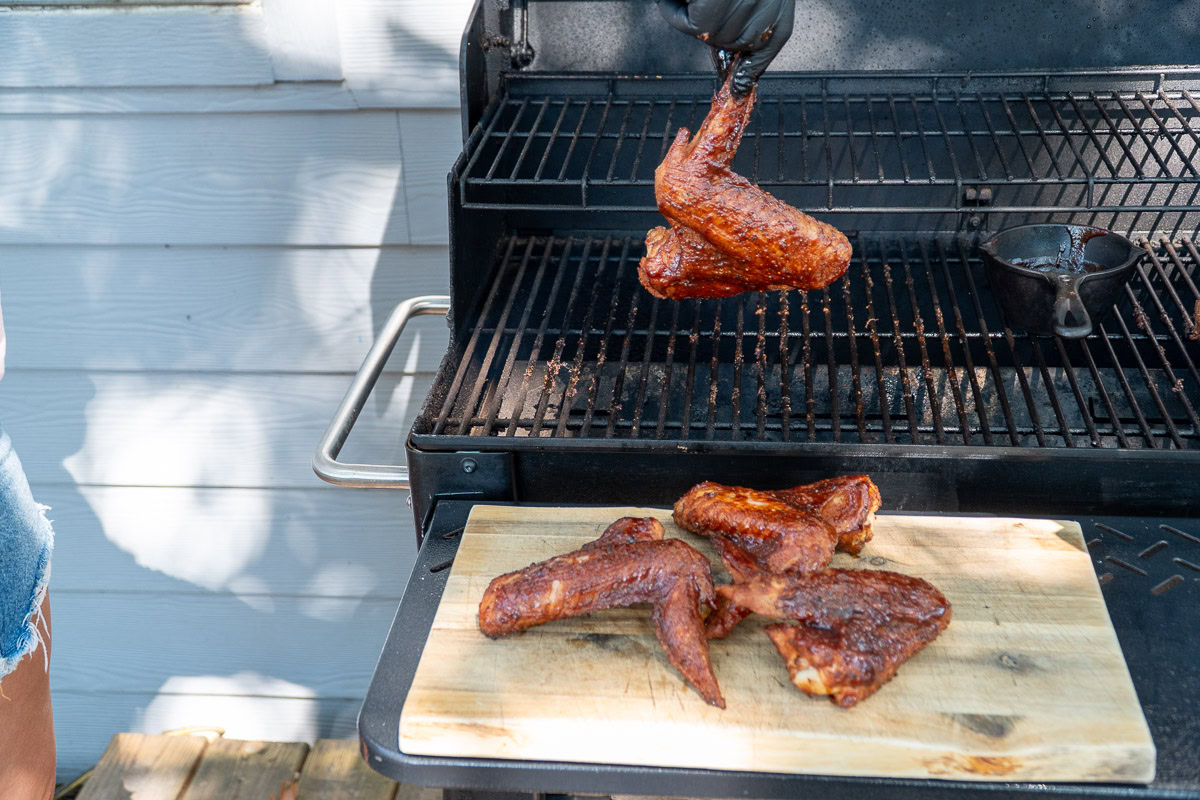 cooked turkey wings being pulled off the smoker