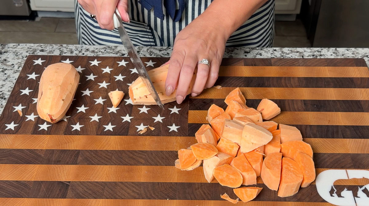 a person chopping sweet potato into cubes