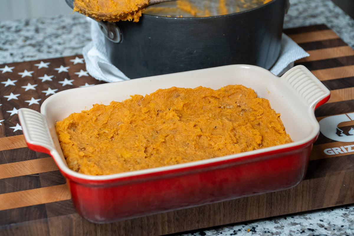 a casserole dish with mashed sweet potato in it