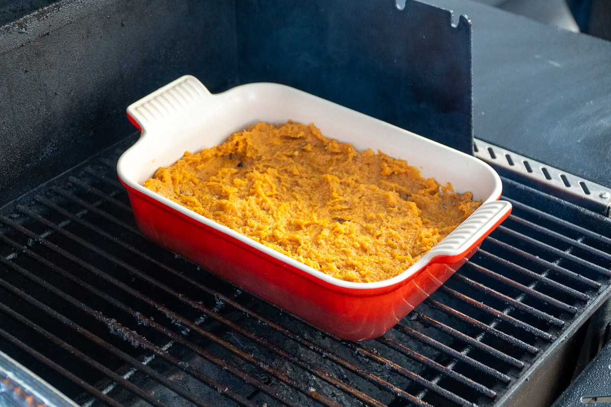 mashed sweet potatoes in a casserole dish in the smoker