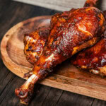 cooked sauced turkey legs on wooden board
