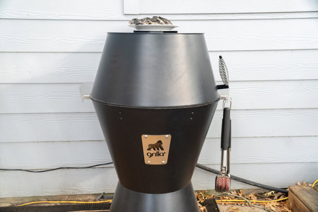 the gorilla grills og pellet smoker with a plate of raw wings on top