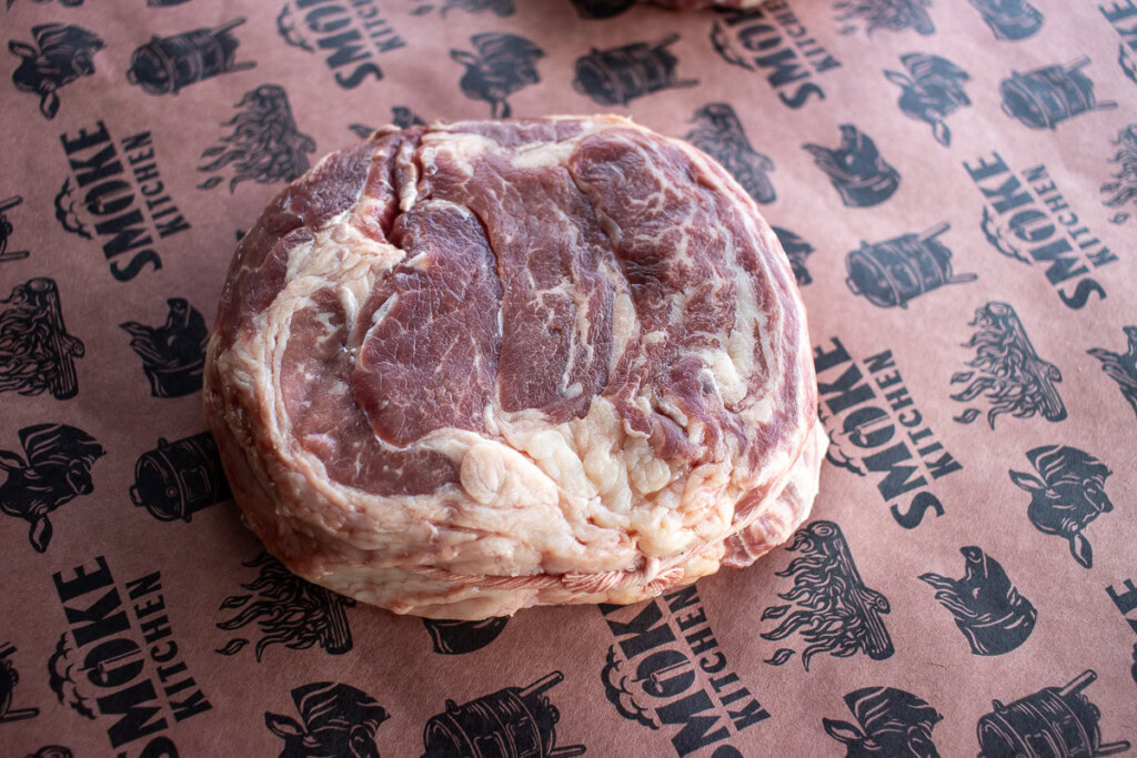 looking down on a raw marbled piece of chuck eye steak on SBS butcher paper