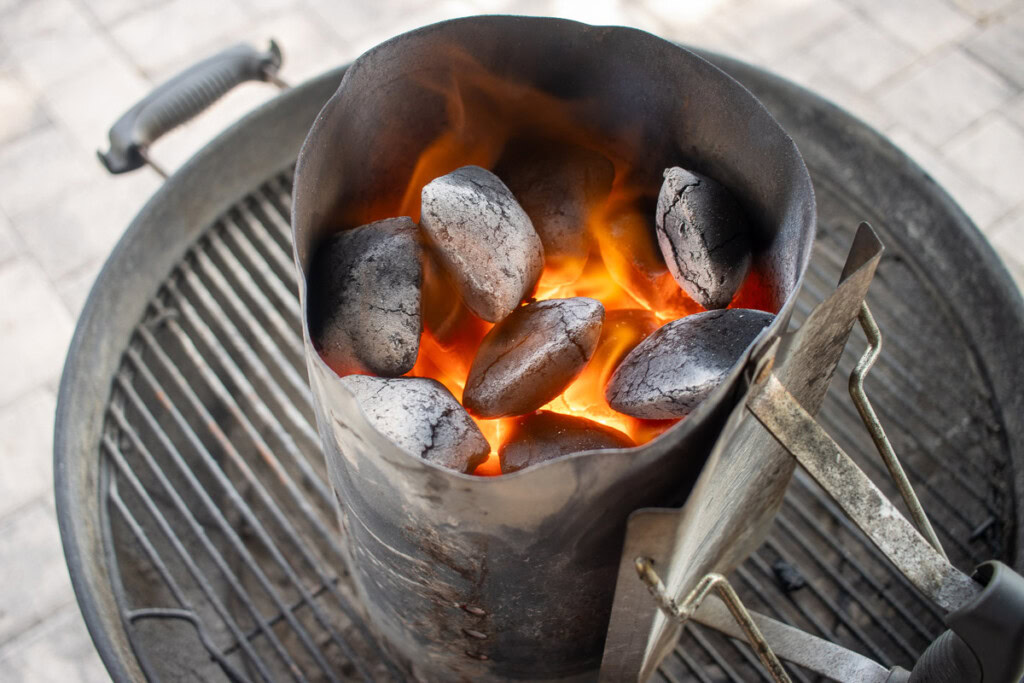 a charcoal chimney with glowing briquettes in it