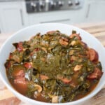 Collard Greens and Sausage plated in a white bowl.