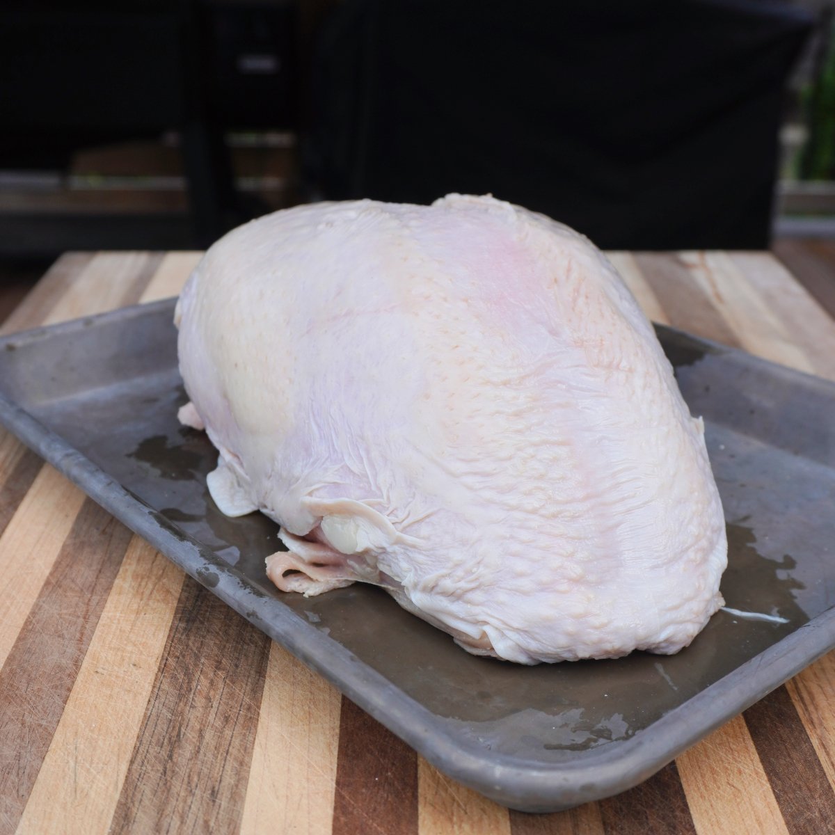 raw turkey breast on grey sheet pan.