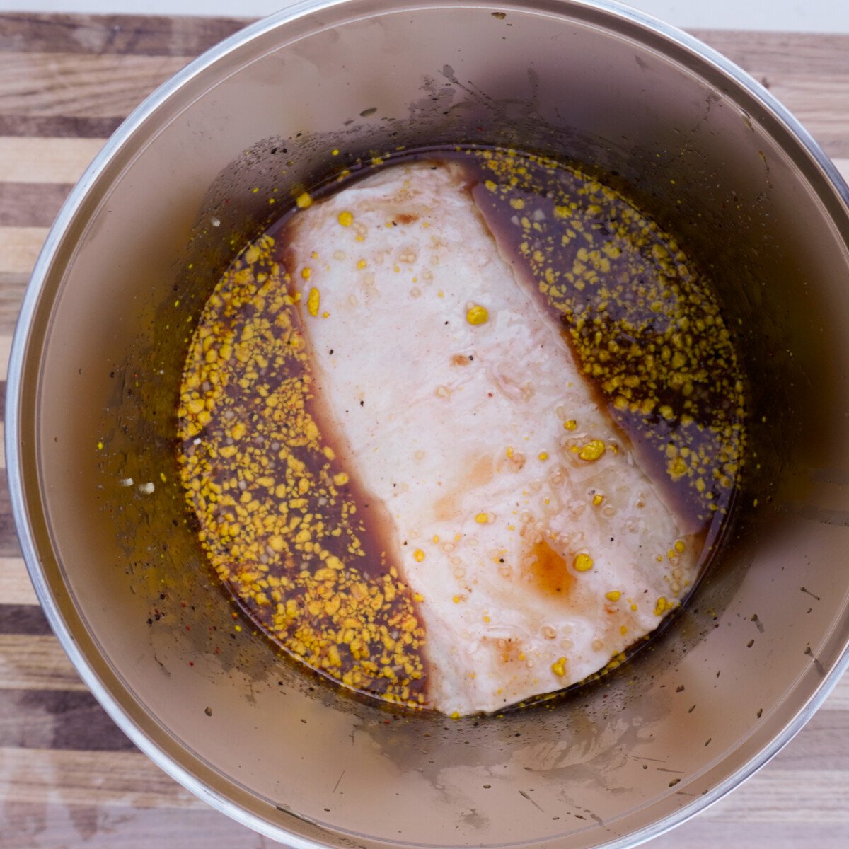 raw pork roast marinating in a apple cider marinade.