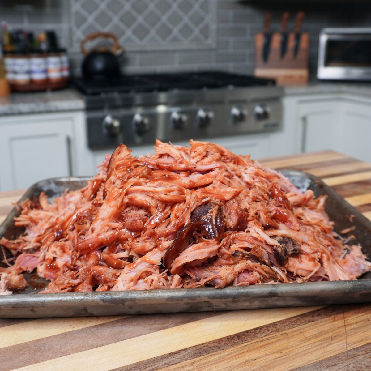 shredded ham with dr. pepper sauce on a tray with the kitchen in the background.