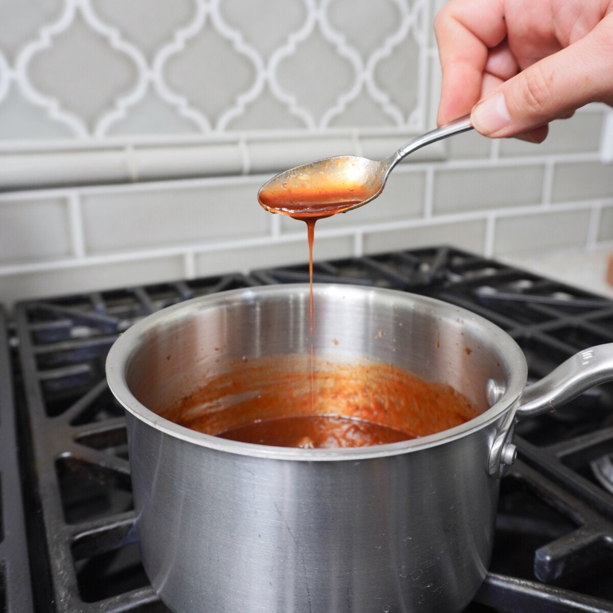 Cherry Dr. Pepper Sauce in saucepan over the stove.