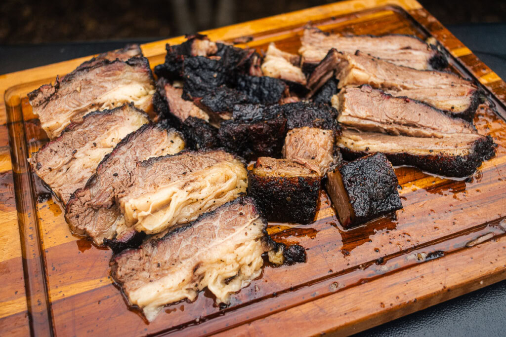a smoked beef belly sliced and cubed on a wooden board