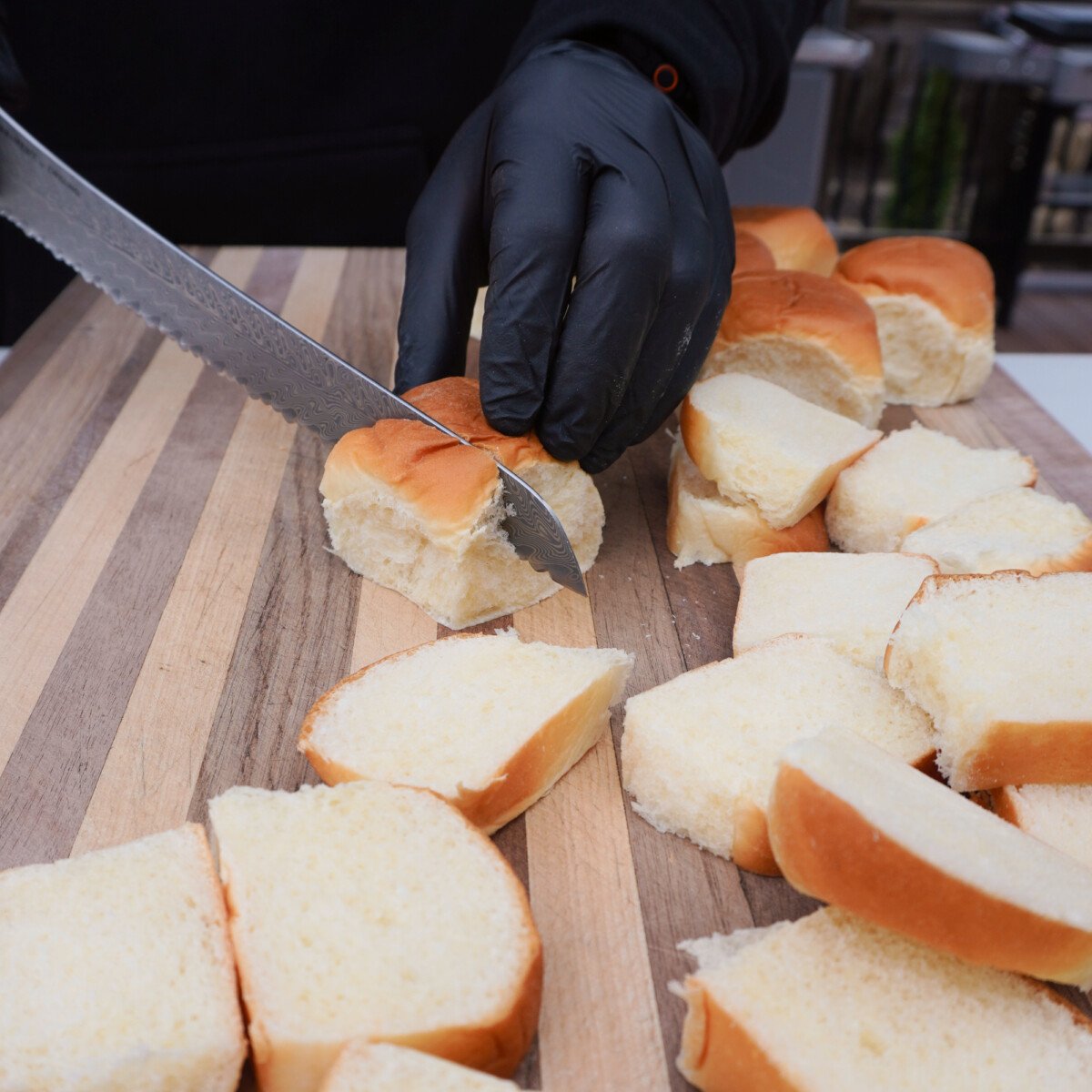slicing kings hawaiian rolls for an easy grilled french toast recipe.