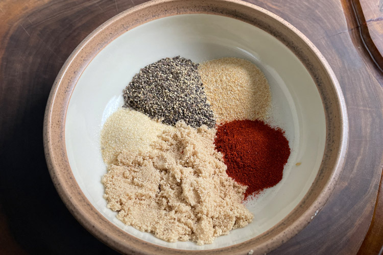 white bowl with, ground pepper, garlic granules, paprika and brown sugar in it