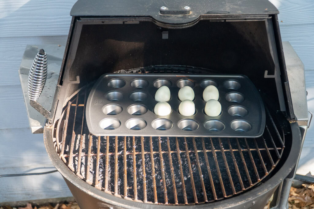 hard boiled eggs in a muffin tray in the grilla grills smoker