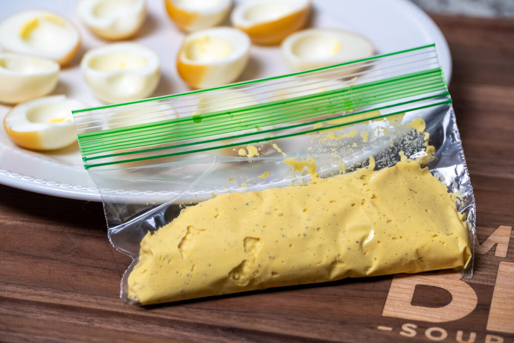 smoked deviled egg filling in a snap lock bag ready to pipe into shells