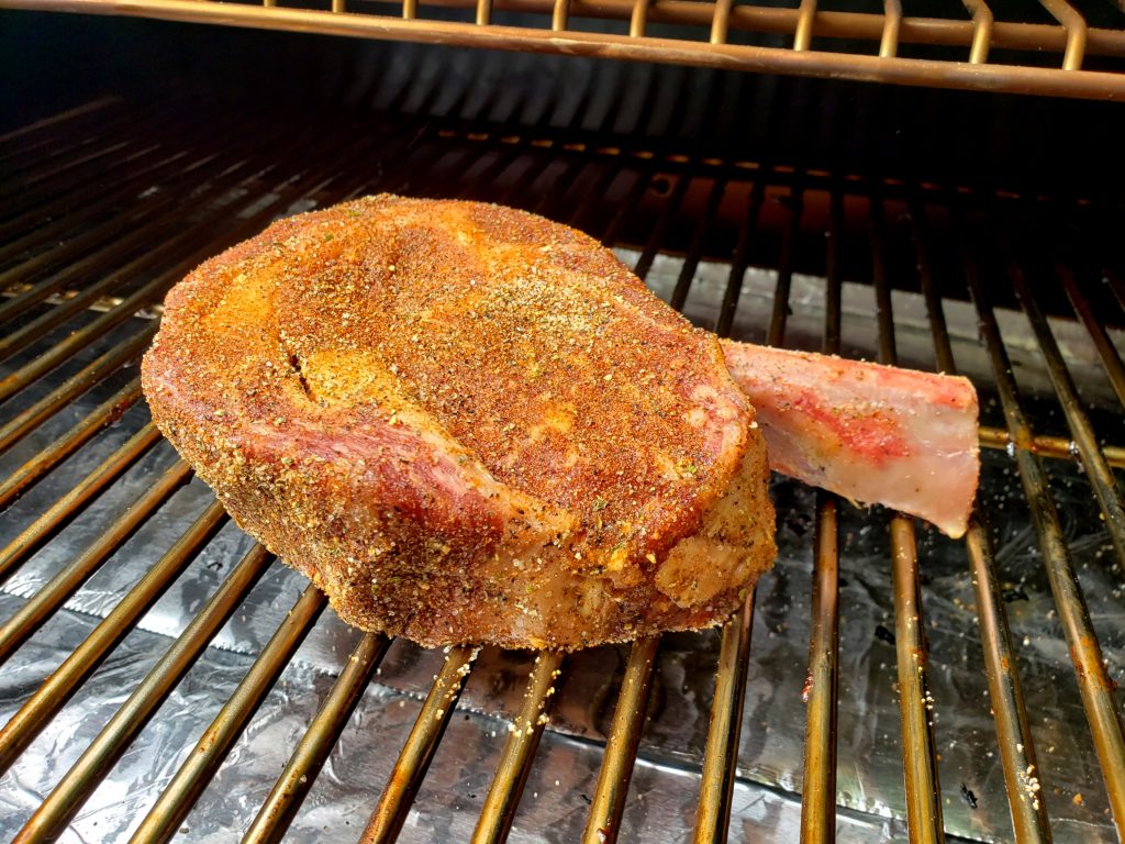 Seasoned steak on pellet grill