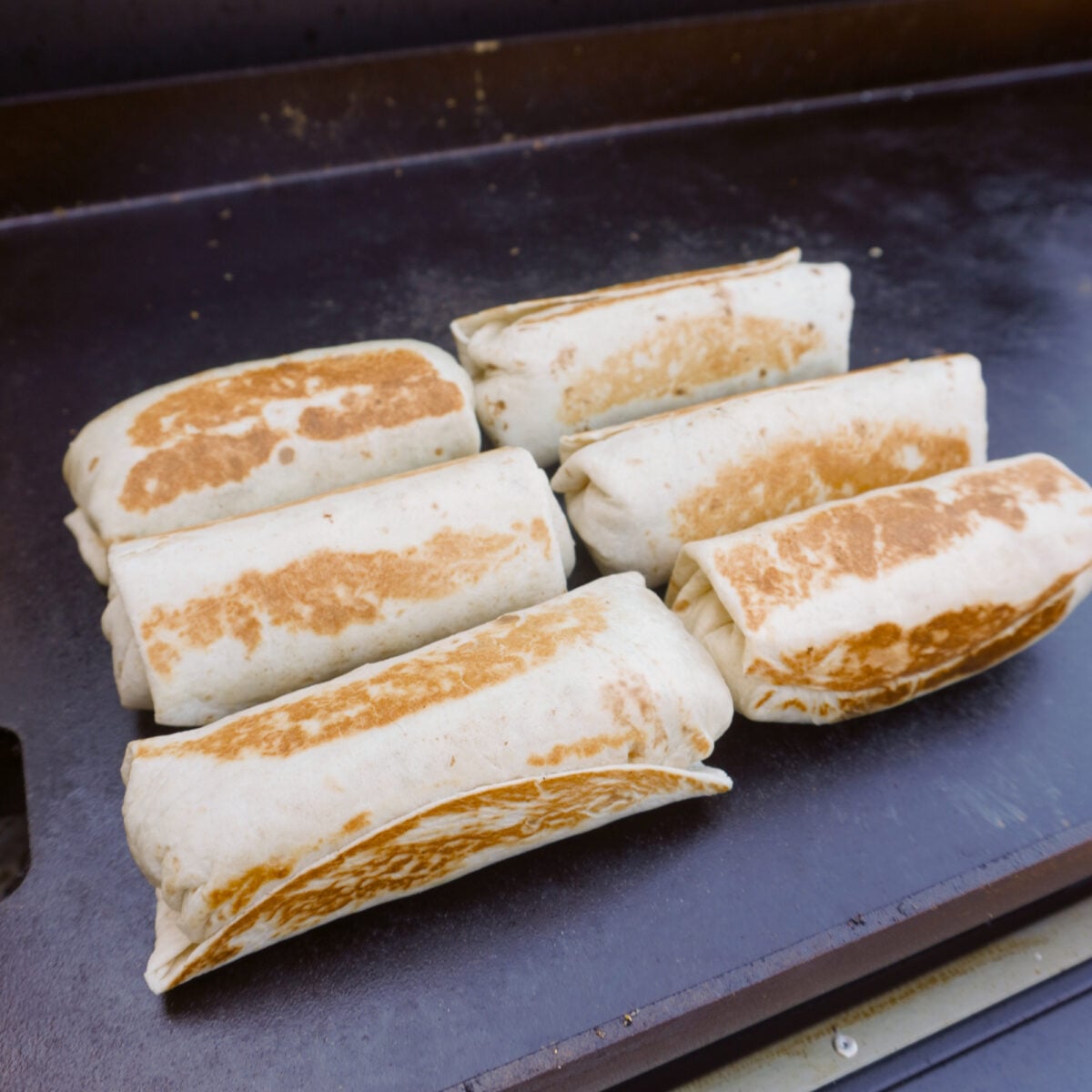 breakfast burritos toasted on the griddle.