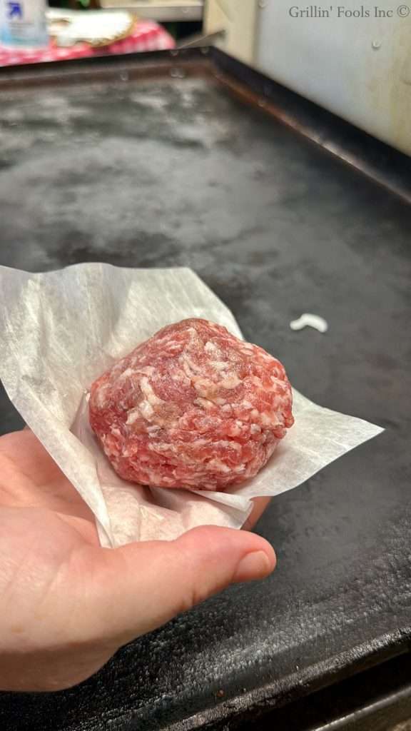 4 ounces of ground pork on a sheet of patty paper