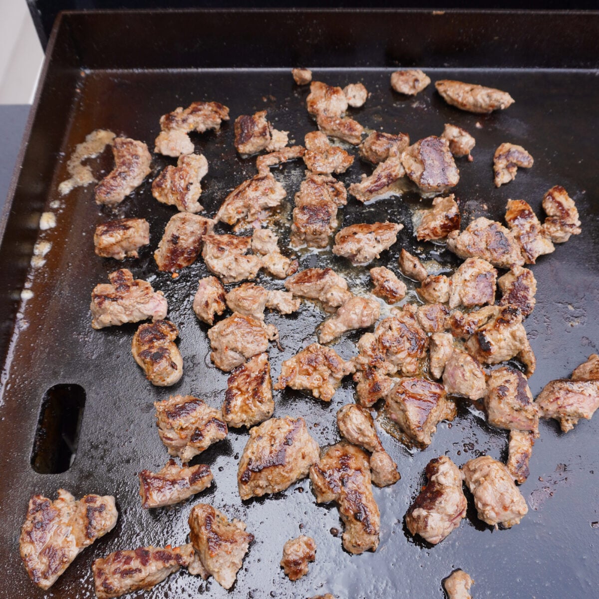 sirloin steak pieces on a griddle.