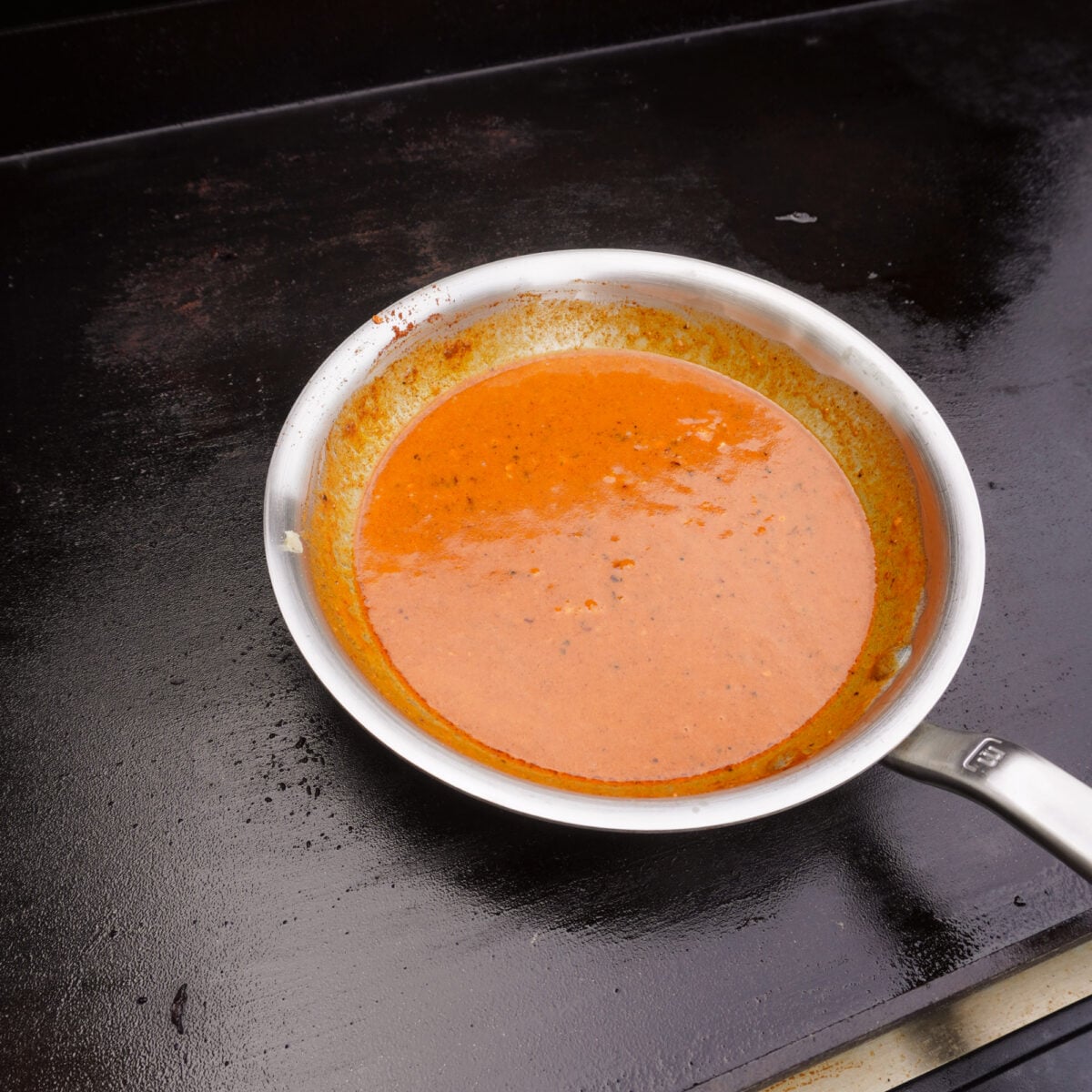 cowboy butter sauce in a saucepan on the griddle.