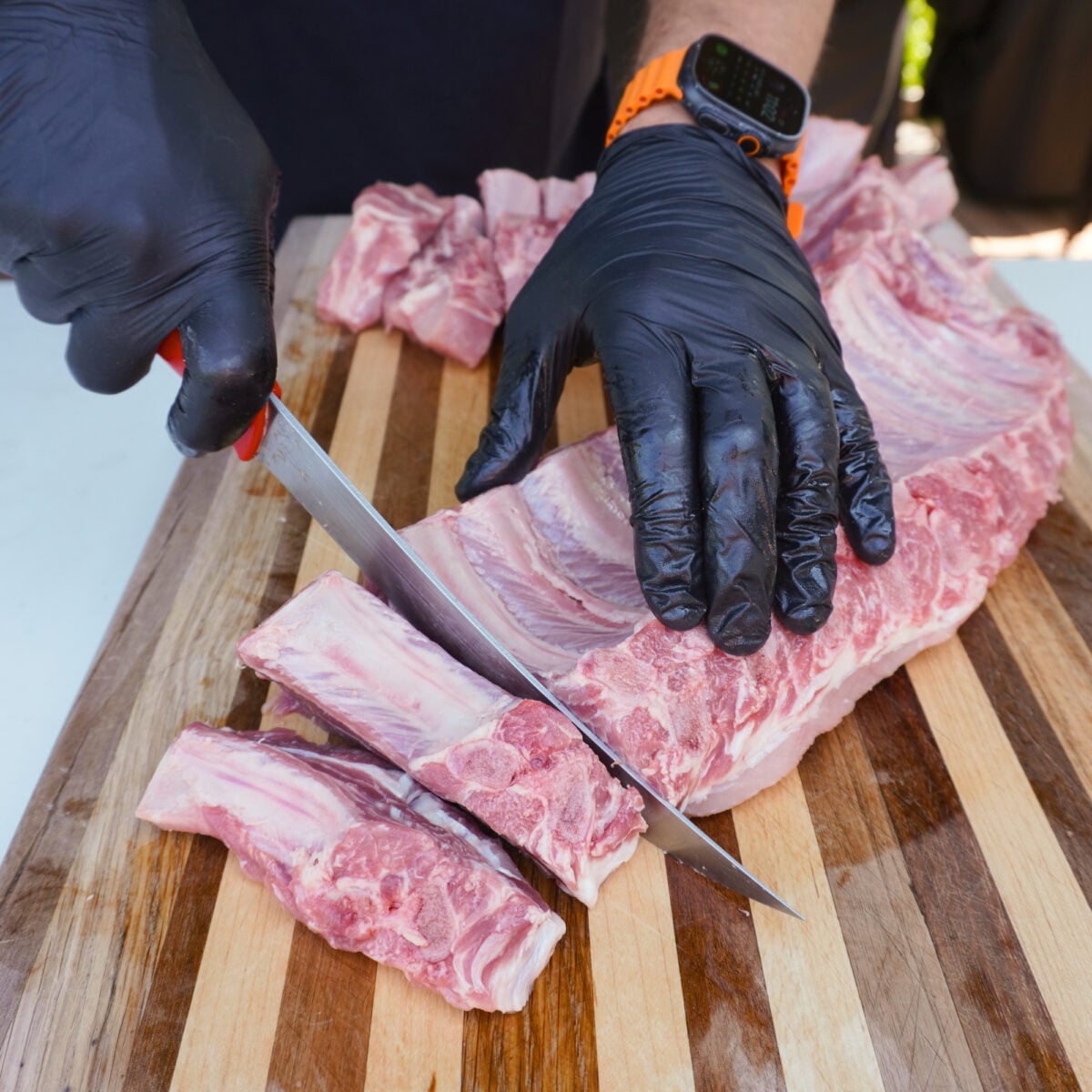 Slicing rack of ribs into party ribs.