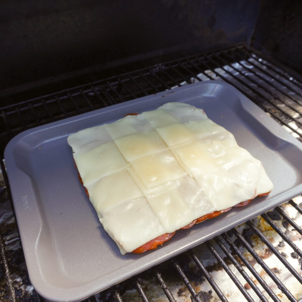melted cheese on sliders on the grill.
